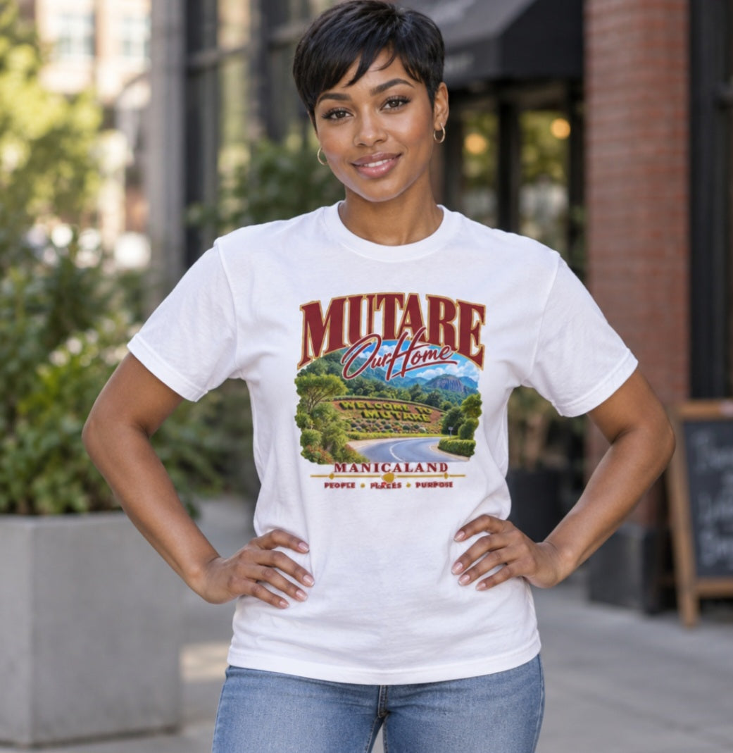 Woman wearing a white Sister Style Mutare t-shirt outdoors, with scenic road artwork and “Mutare Our Home” lettering.