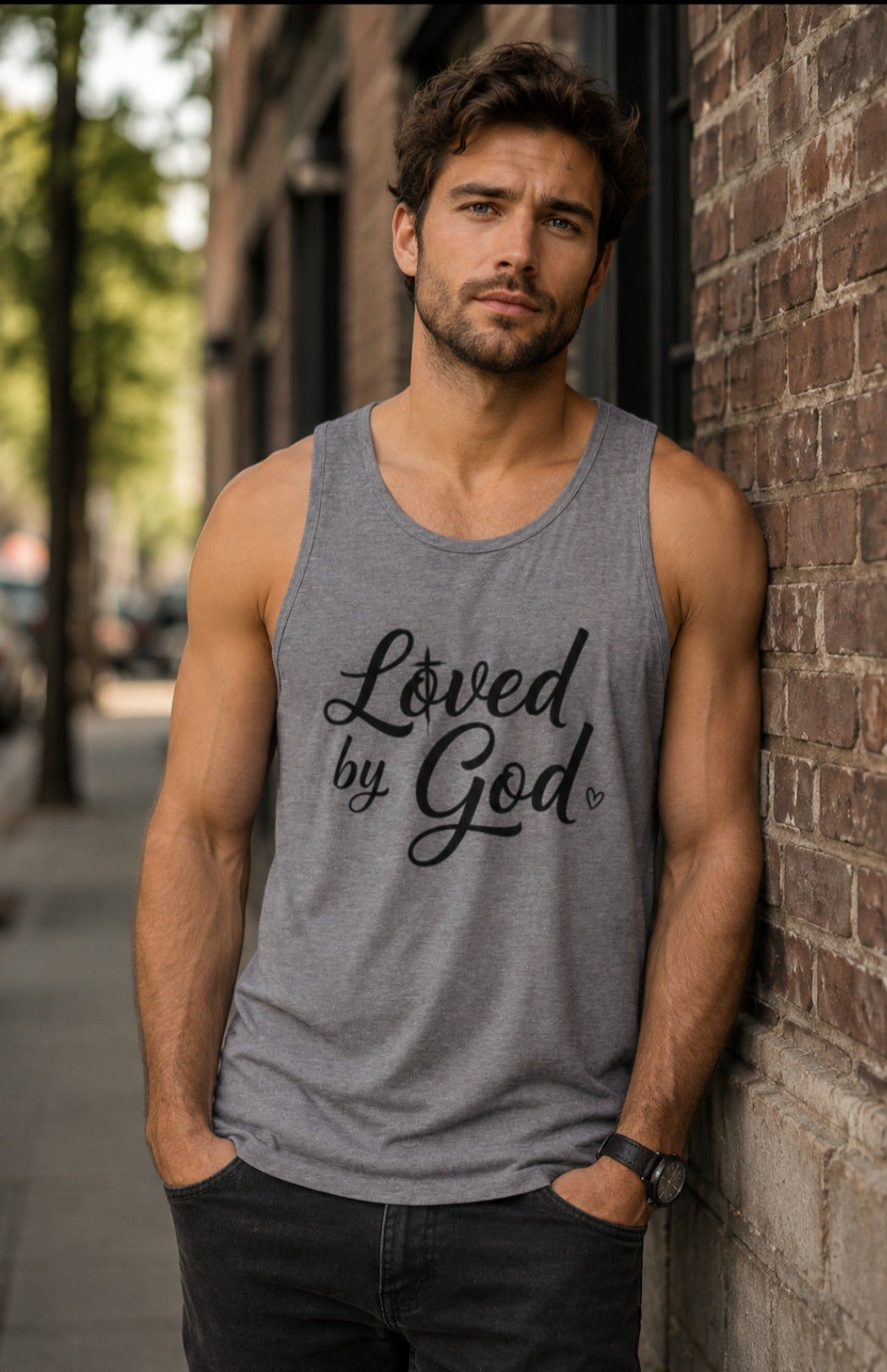 Man wearing grey Loved by God tank top against brick wall – Sister Style Christian Faith Streetwear"