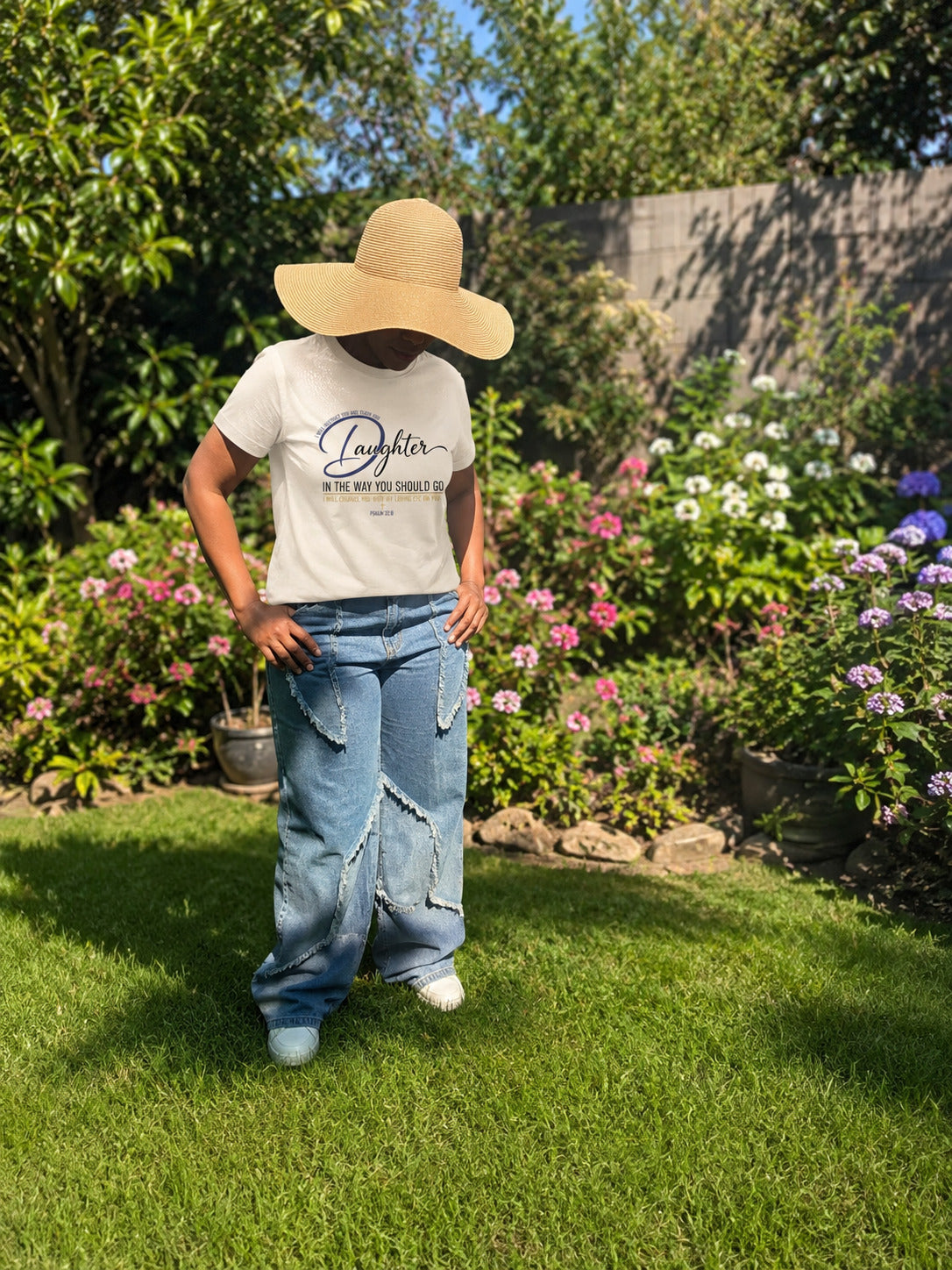 Woman wearing the Daughter Tee by Sister Style in a garden — Christian faith streetwear African heritage