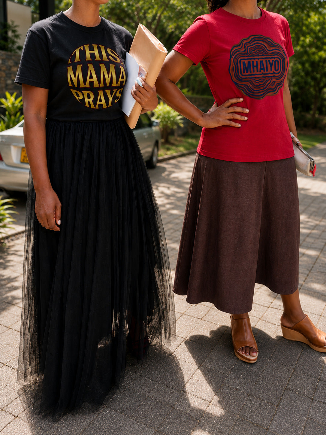 Close up of This Mama Prays black tee and Mhaiyo red tee by Sister Style — Christian faith African heritage streetwear