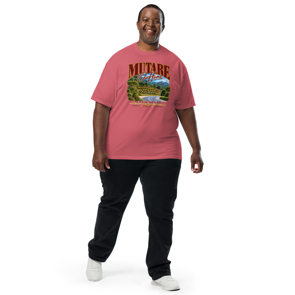 Man wearing a watermelon pink Sister Style Mutare t-shirt with scenic artwork and “Mutare Our Home” lettering, full-length front view.