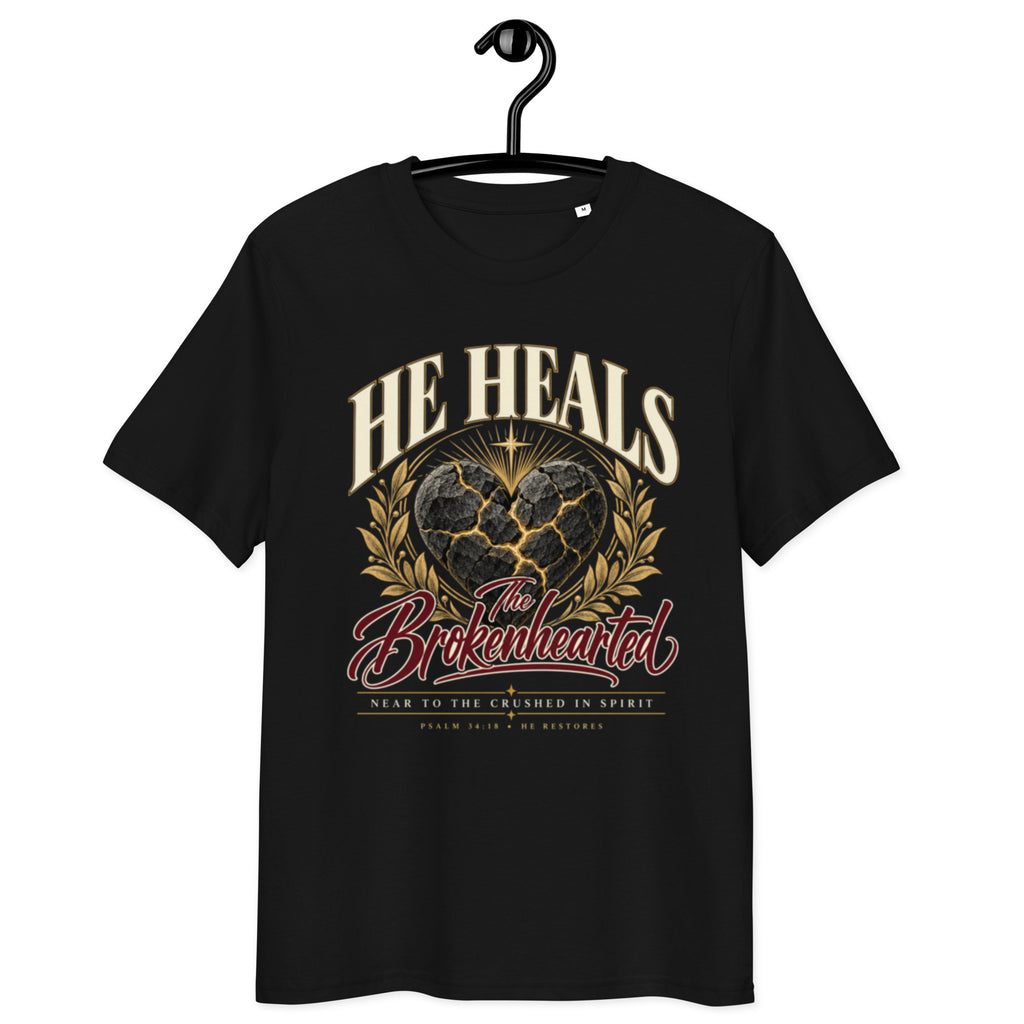 Front view of black He Heals the Brokenhearted t-shirt on a hanger, showing heart artwork and “Near to the crushed in spirit” lettering.