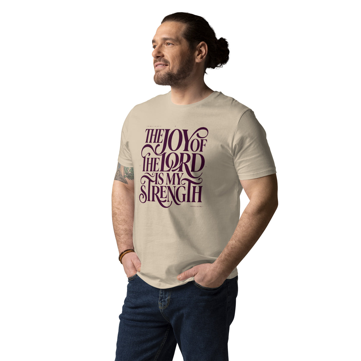Man wearing a Desert Dust Joy of the Lord organic cotton t-shirt with “The Joy of the Lord Is My Strength” lettering, angled front view.